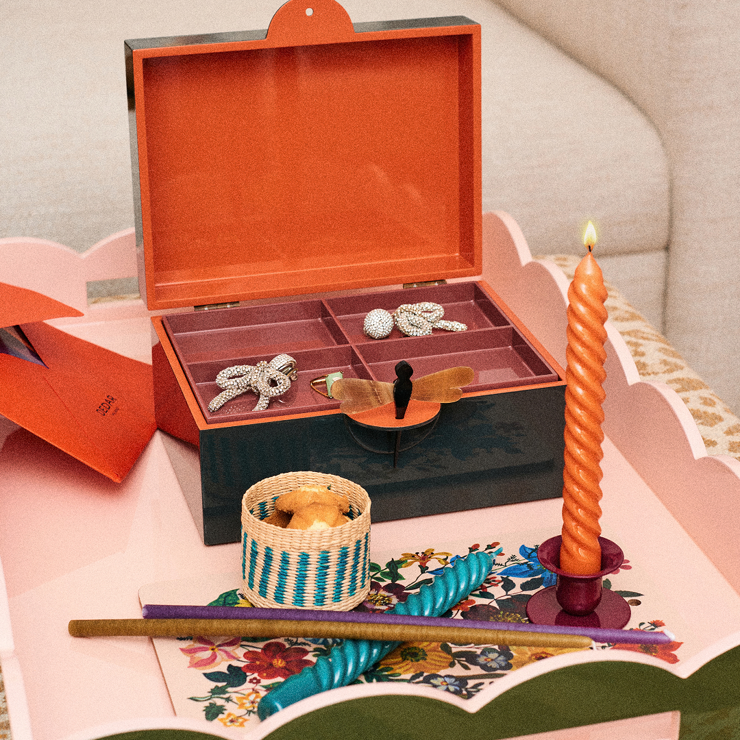 Mesa decorada con jarrones con flores y un cuadro al fondo